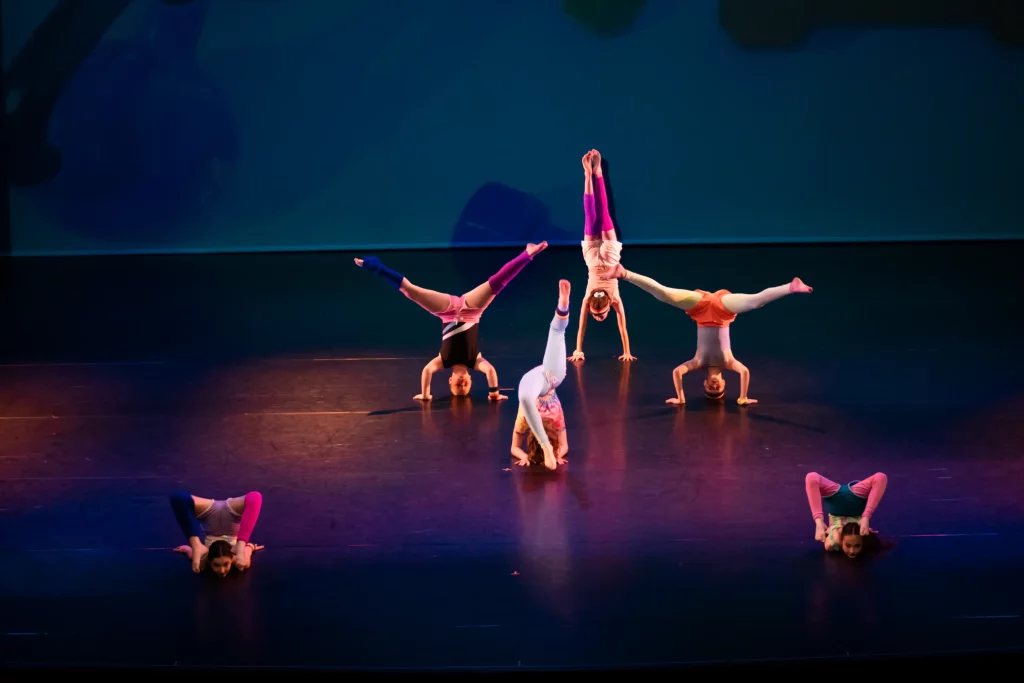 An acro dance class recital with students performing